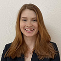 Ich kann die Person auf dem Foto nicht identifizieren. Es zeigt eine lächelnde Frau mit langen Haaren vor einem neutralen Hintergrund.