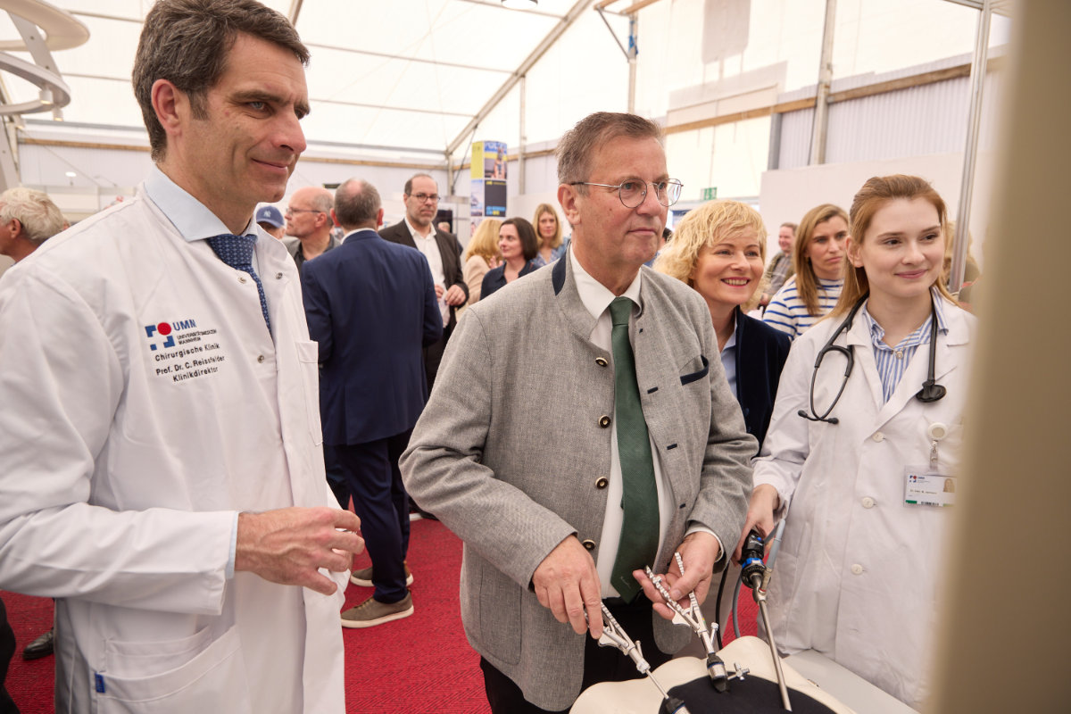 Landwirtschaftsminister bedient medizinisches Gerät an Messestand
