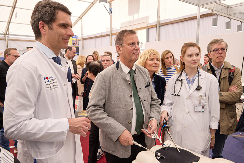 Landwirtschaftsminister bedient medizinisches Gerät an Messestand